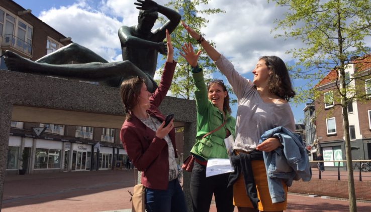 Team geeft elkaar een high five tijdens een dagje uit Arnhem